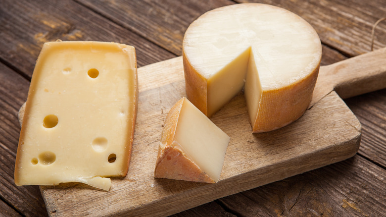 Various cheeses on a wooden presentation board