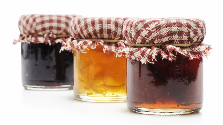 Homemade jars of jellies and jams on white background