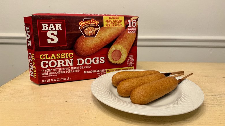 A plate of prepared Bar-S Corn Dogs next to the box