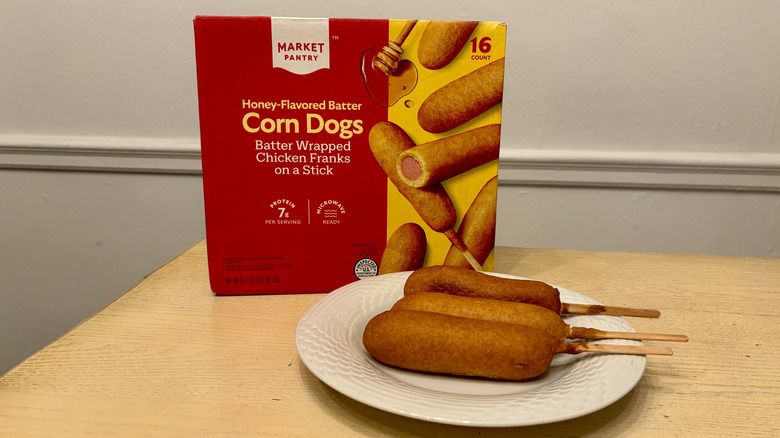 A plate of prepared Market Pantry Corn Dogs next to the box