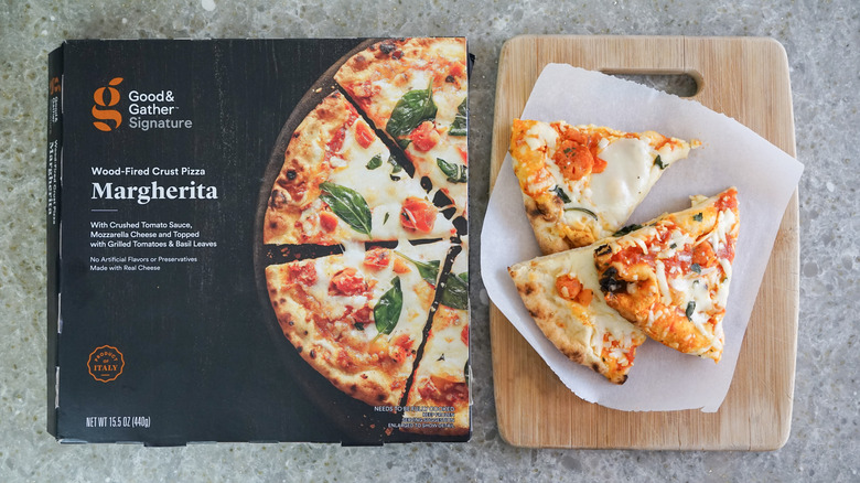 Good & Gather Signature Wood-Fired Margherita Frozen Pizza next to slices on cutting board