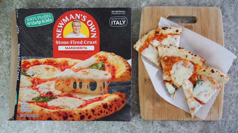 Newman's Own Margherita Stone Fired Crust Frozen Pizza next to slices on cutting board