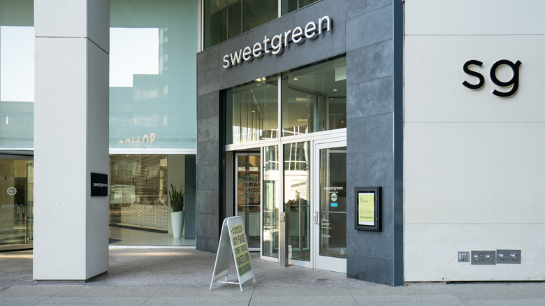 Exterior shot of a Sweetgreen restaurant with someone riding their bike nearby
