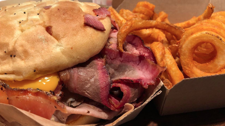 A close up of an Arby's Brisket Beef 'n Cheddar with curly fries