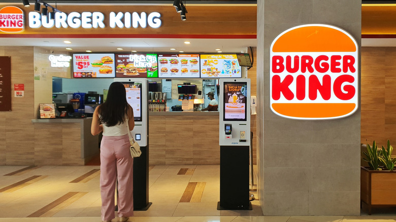 A woman ordering at a Burger King kiosk