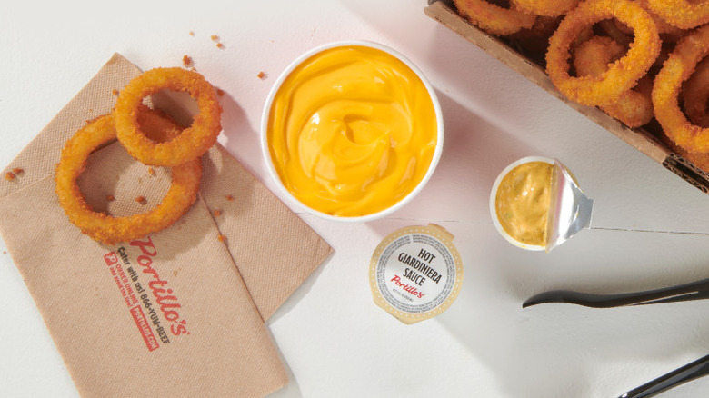 Portillo's jumbo onion rings next to a side of cheese sauce