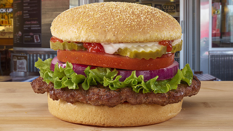 Side of Portillo's beef gravy next to a Portillo's hamburger with the works