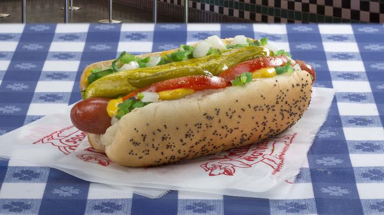 Portillo's hot dog dragged through the garden on blue and white checked tablecloth