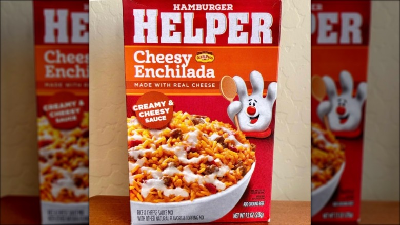 Box of Hamburger Helper Cheesy Enchilada against beige wall