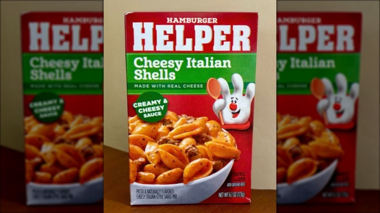 Box of Hamburger Helper Cheesy Italian Shells on brown, wooden table