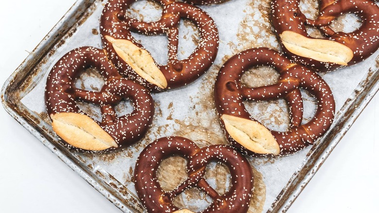 Salted pretzels neatly lined up on a paper lined sheet tray