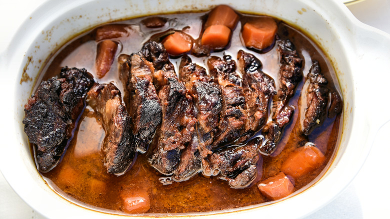 Beef brisket braised in wine in a white oval casserole dish