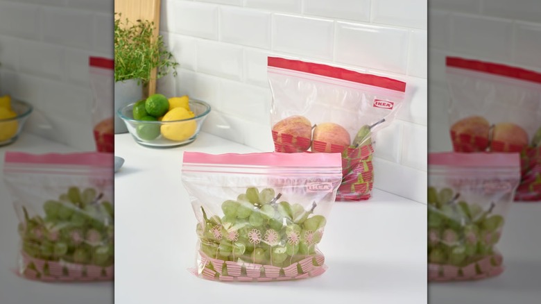 ISTAD resealable bags in pink and red on a countertop with fruit inside them