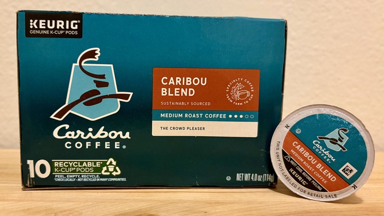 A box of Caribou Blend K-Cups, next to a single coffee pod