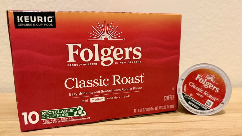 A box of Folgers K-Cups next to a single coffee pod