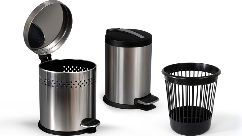 Three garbage cans against a white background