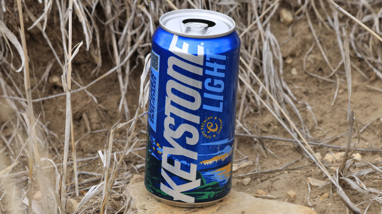 Can of Keystone Light sitting on a rock outdoors