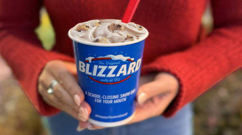 A person holding a Chocolate Chip Cookie Dough Blizzard from Dairy Queen