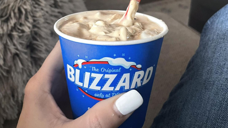 A person holding a Turtle Pecan Cluster Blizzard from Dairy Queen