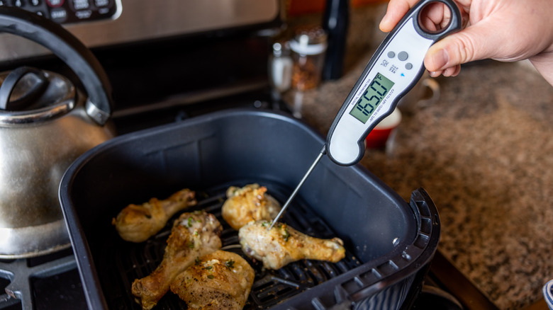 Testing chicken with meat thermometer