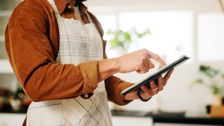 Person with tablet reviewing recipe