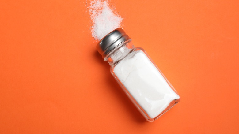Salt shaker against orange background