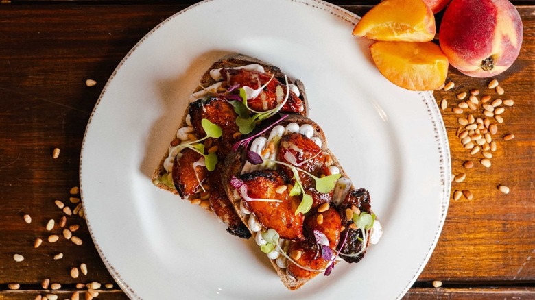 A white plate with two gourmet pieces of toast on a wooden background