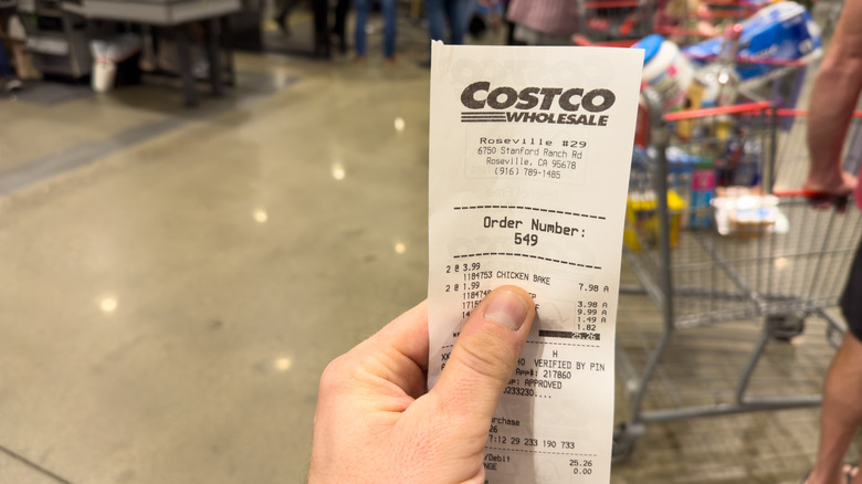Hand holding a Costco receipt