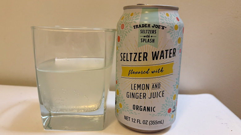 A glass of Seltzer Water flavored with Lemon and Ginger Juice next to its can.