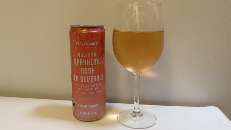 A glass of Organic Sparkling Rosé Tea Beverage next to its can