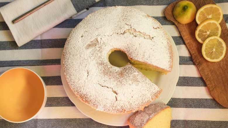 Overhead shot of lemon chiffon cake on a striped dish towel with lemon slices