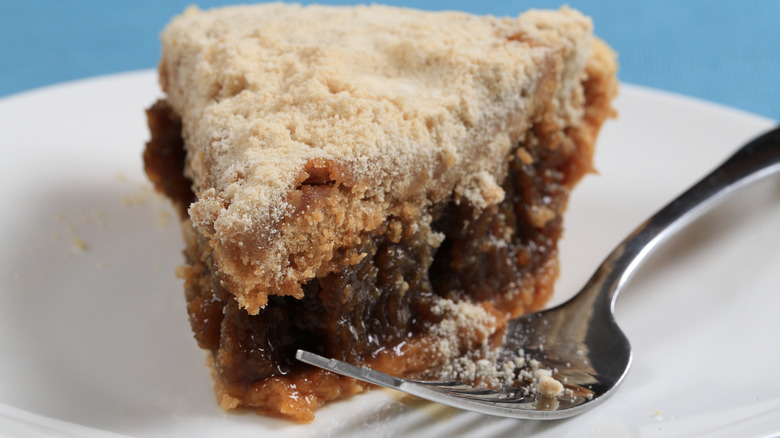 A close up of a slice of shoofly pie with a fork beside it