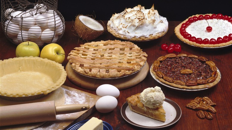 Assortment of pies and pie ingredients on a dark wooden table