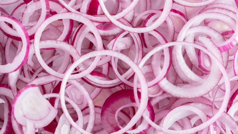 Rings of raw red onions erratically stacked on top of each other