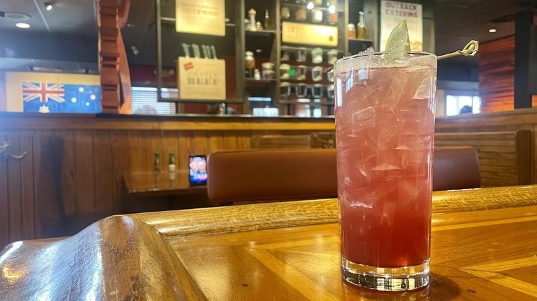 Outback Steakhouse's Cherry Berry Shine cocktail on a wooden bar top