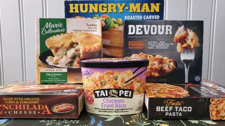 An assortment of frozen dinners from various brands piled on a table