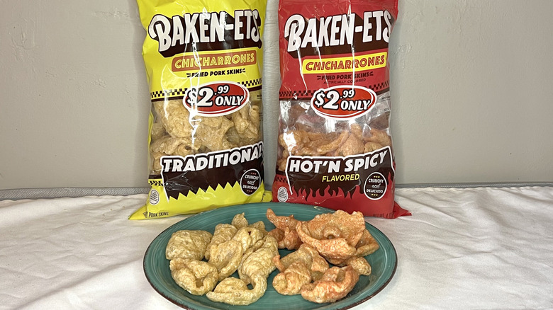 Two bags of Baken-Ets Chicharrones with pieces on a green plate