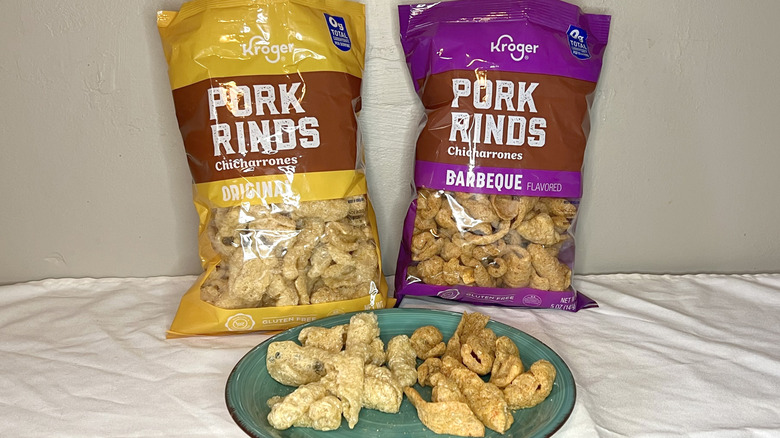 Two bags of Kroger pork rinds with pieces on a green plate