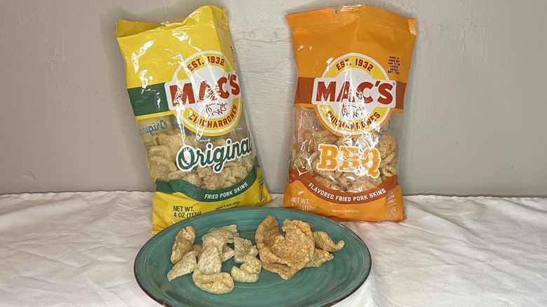 Two bags of Mac's pork rinds with pieces on a green plate