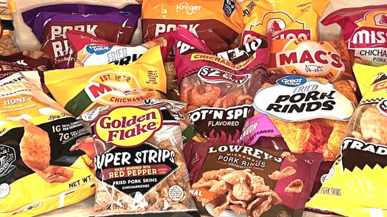 Variety of bags of pork rinds against beige wall