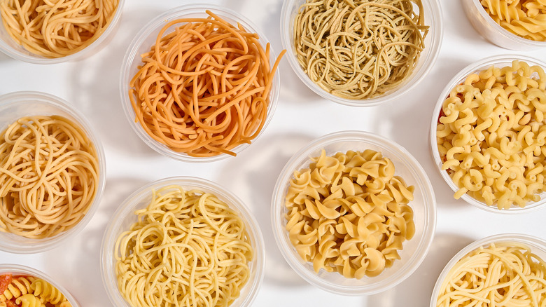 Cooked pastas in deli containers on a table