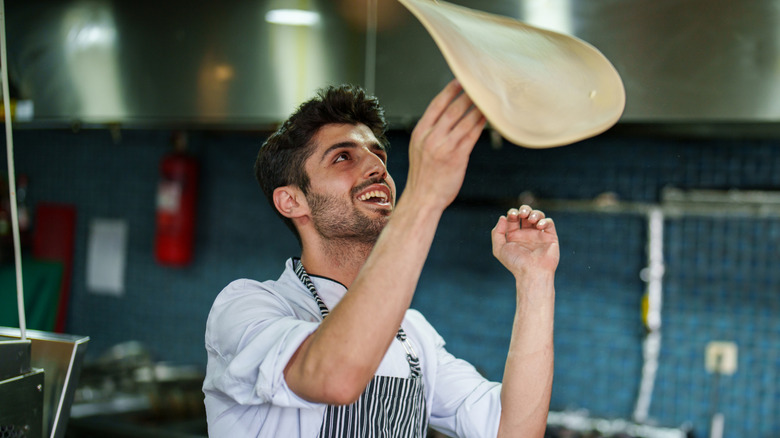 Man tossing pizza dough