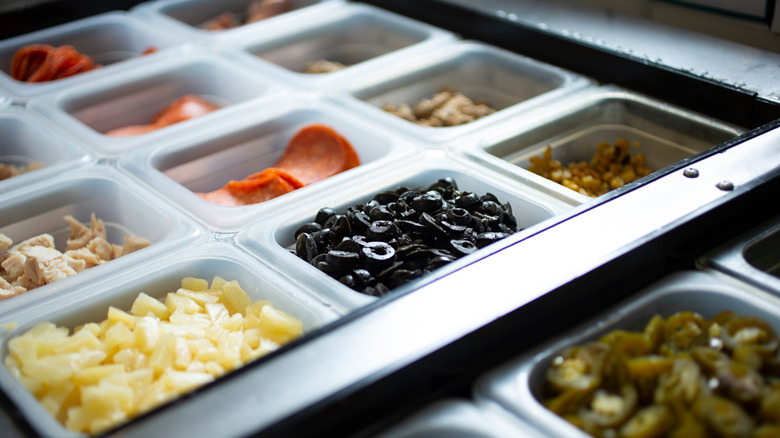 Pizza ingredients in prep compartments