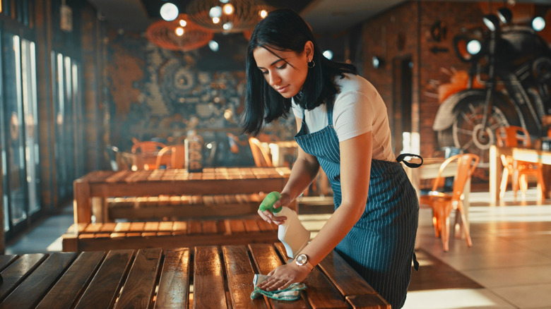 Woman cleaning restaurant table
