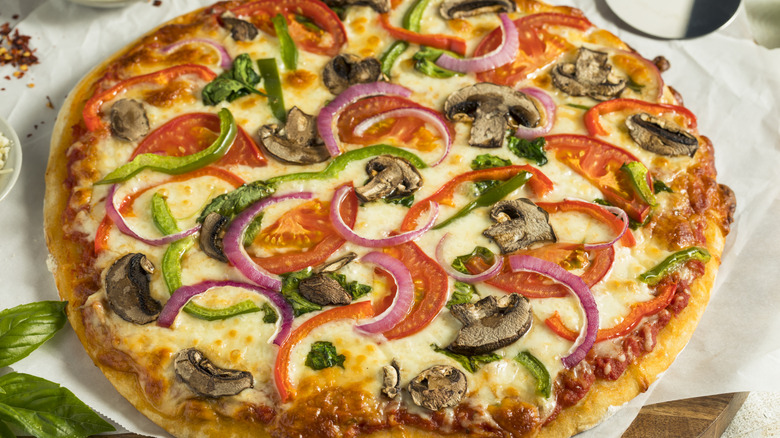 Fresh veggie pizza with onion, mushrooms, tomato, and green pepper