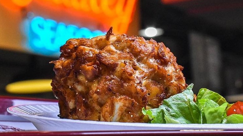 A crab cake on a paper plate at Faidley's Seafood in Baltimore