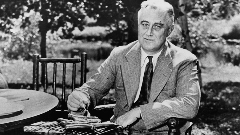 Franklin D. Roosevelt grilling hot dogs on a small tabletop grill