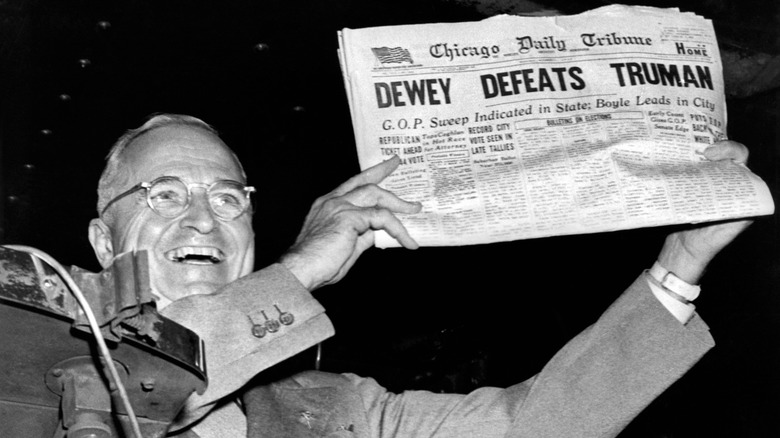 Harry Truman holding paper with headline stating, "Dewey Defeats Truman" after Truman won his election