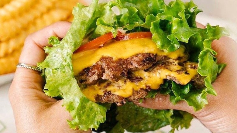 a Shake Shack lettuce burger with cheese, tomato and two Angus beef patties