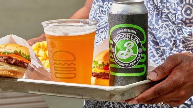 A cold can of ShackMeister Ale by a Shake Shack Shandy in a transparent cup
